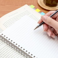 付箋を貼ったノートにペンで書き込む手元の写真