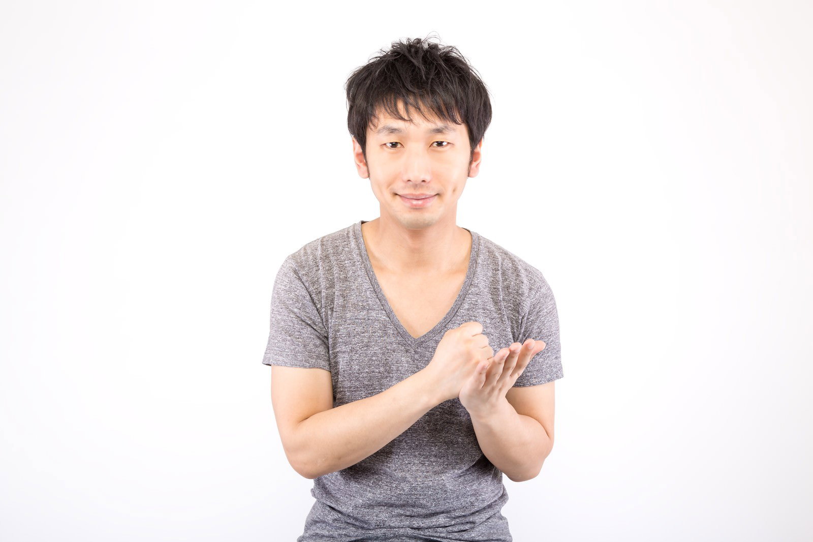 白背景で両手を組んで思いついた表情の半袖男性［モデル：大川竜弥］