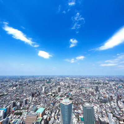 青空の下にオフィスビルが立ち並ぶ都会の街並みの風景の写真