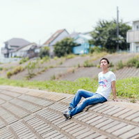 土手で日向ぼっこ中の無職の男性の写真