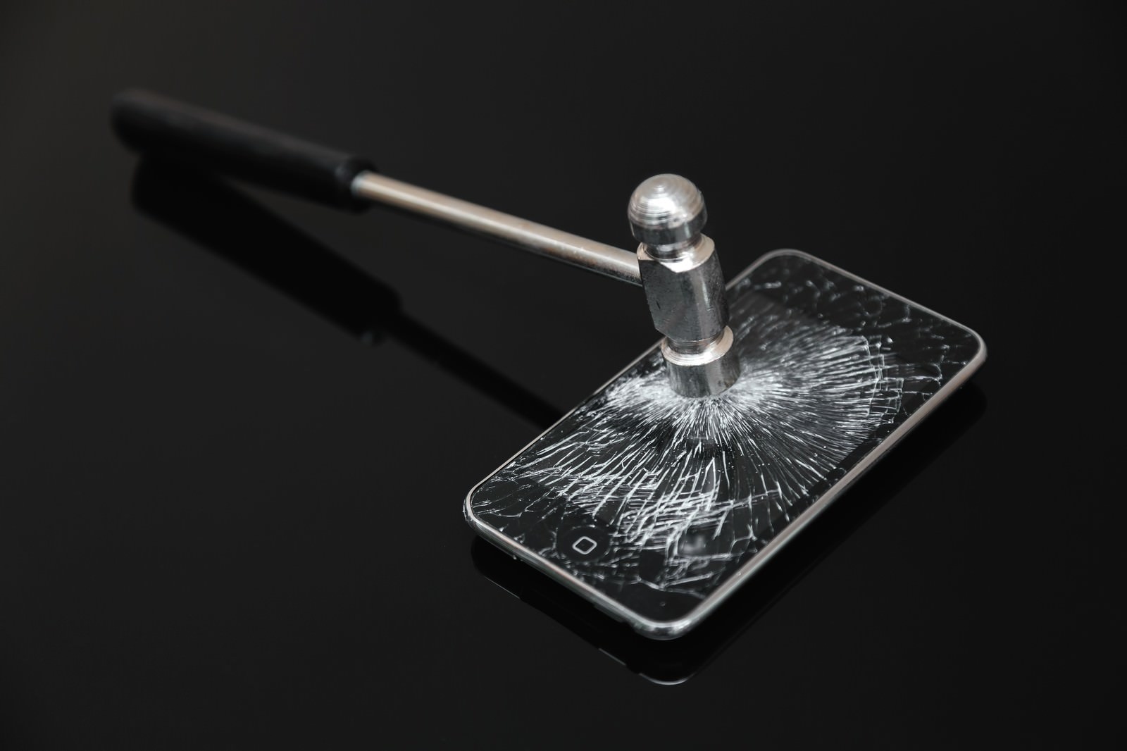 ハンマーで画面を叩き割られたスマートフォン