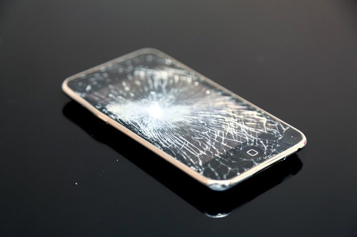 画面がバリバリに割れたスマートフォン