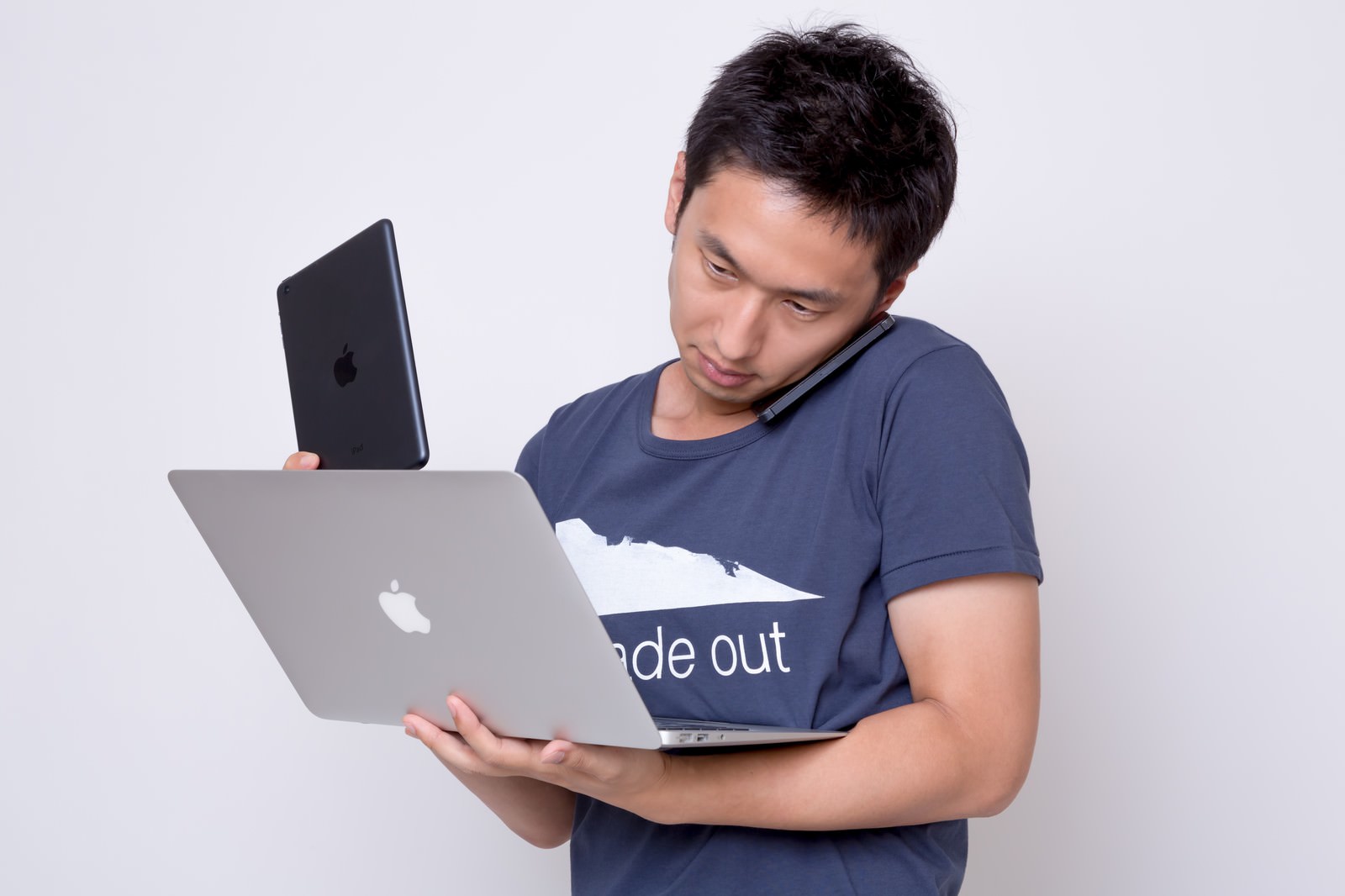 複数のデバイスを操作する男性がiPhoneとiPad、MacBook Airを同時に使用している［モデル：大川竜弥］