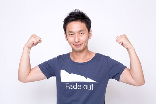 力こぶポーズで元気をアピールする男性