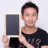 小さな黒板を持って見せる男性の写真