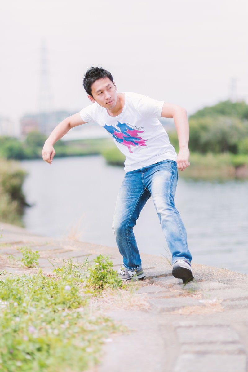 河川敷で水切りをする白いTシャツの男性［モデル：大川竜弥］