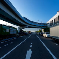 高架のモノレールと地上で渋滞する車の列が並ぶ都市風景の写真