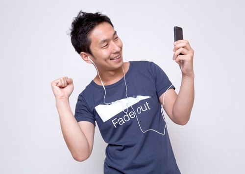 イヤホンで音楽を聴いてノリノリの男性