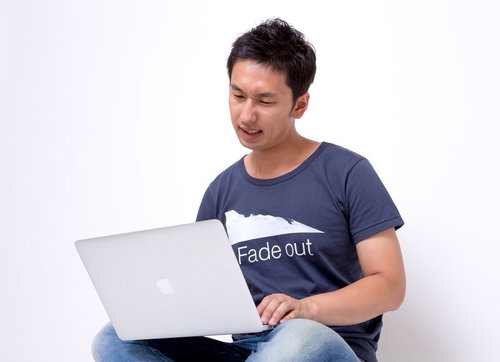 ノートパソコンを見て渋い顔のフリーランス男性