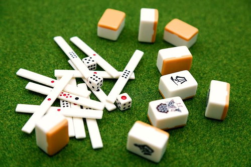 緑のマット上に散らばる麻雀牌とサイコロ