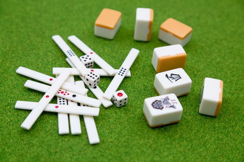 白い点棒と色とりどりの麻雀牌が並ぶ卓上の風景