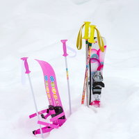 雪の上に立てたピンクのキッズ用スキー板とストックの写真