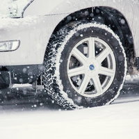 雪が積もりタイヤチェーンを巻いた車の写真