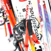 立てかけた複数のスキー板とストックのグリップの写真