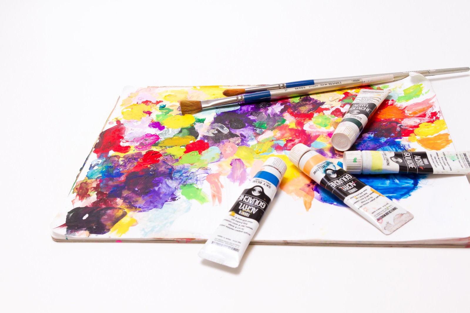 パレットの上に並ぶ絵具チューブと筆