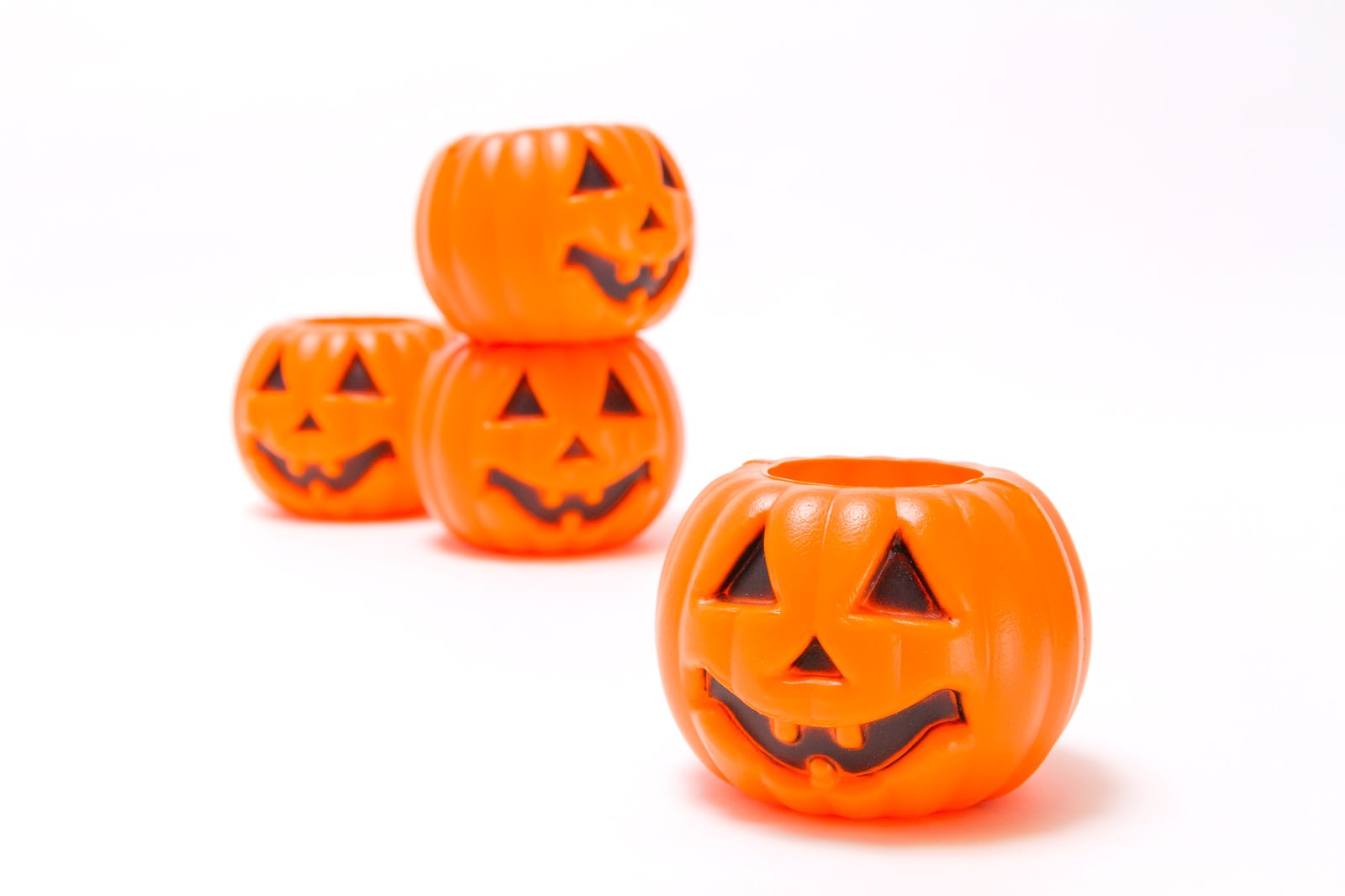 ハロウィン用のオレンジ色のかぼちゃのおもちゃが積み重ねられている