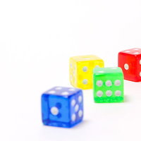 赤青緑黄の透明なカラフルサイコロ4個の写真