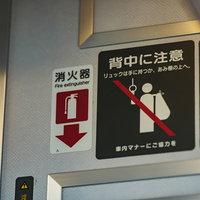 電車内は背中の荷物に注意を促すピクトグラム表示の写真