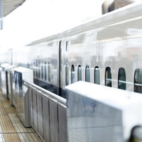 駅のホームに停車中の白い新幹線の写真