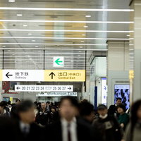 新幹線乗り場の人混みと天井の案内板、乗降風景の写真