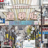 道頓堀の入り口に並ぶカラフルな看板と商店街の写真
