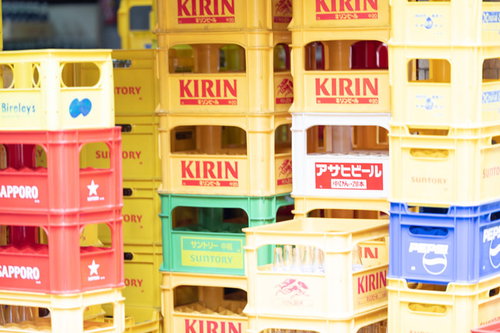 酒屋に積み重ねられたキリンなど複数ブランドの空きビールケース