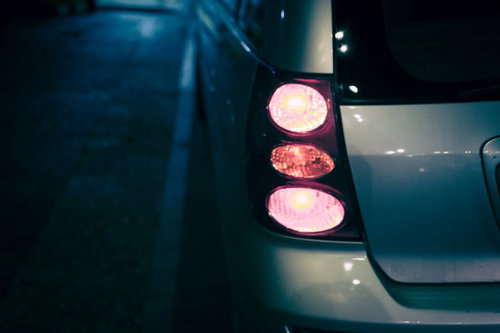 暗闇で光る水色の車の丸いテールランプ