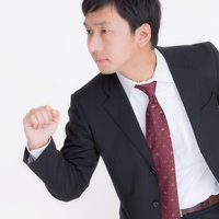 横向きで拳を握るスーツ姿のビジネスマンの写真
