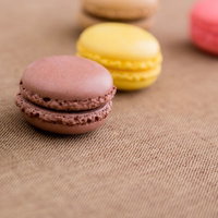 茶色い布の上に横一列に並んだマカロンの写真