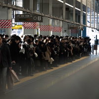 駅ホームに列をなす通勤ラッシュの人々の写真