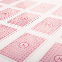 白い台の上に裏向きに並べたピンクのトランプの写真