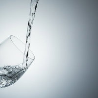 ワイングラスに注がれる水と泡の瞬間の写真