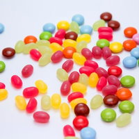 白い平面に散らばるマーブルチョコとビーンズの写真