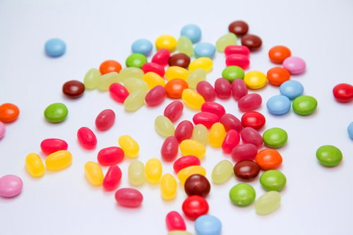 白い平面に散らばるマーブルチョコとビーンズ