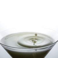 グラスに落ちる水滴と波紋の瞬間の写真