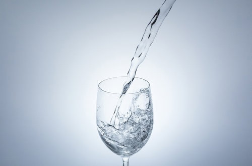 ワイングラスに水を注いで跳ねる飛沫