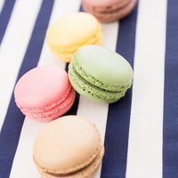 青と白の縞模様の布の上に並ぶマカロンの写真