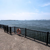 埠頭の柵に立てかけられた釣竿と浮き輪の写真