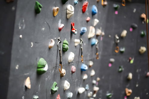 カラビナが下がるボルダリング壁とホールド