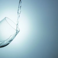 ワイングラスに水を注ぐ瞬間の写真