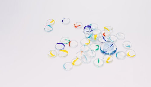 白背景に散らばるカラフルな透明リング