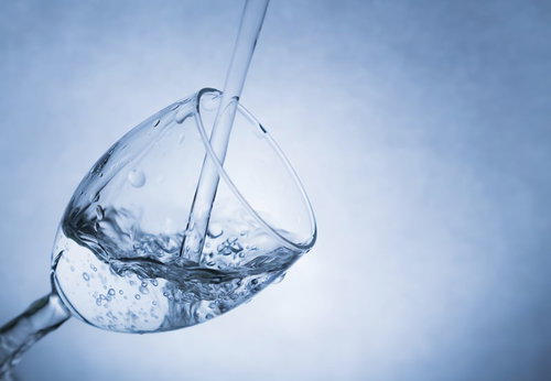 透明なグラスにお水がきれいに注がれる瞬間の接写