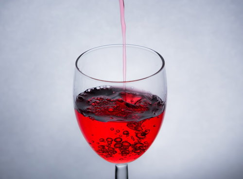 透明なグラスに赤い液体がきれいに注がれる瞬間
