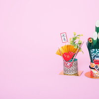 金色の扇と赤い飾りが付いた2つの正月飾りの年賀状素材の写真