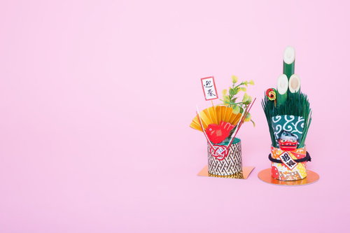 金色の扇と赤い飾りが付いた2つの正月飾りの年賀状素材