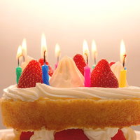 ケーキのロウソクに火をつけて「おめでとう」の写真