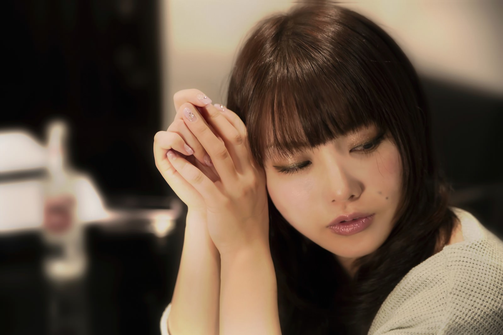 両手を顔に添えて目を閉じる女性［モデル：Lala］