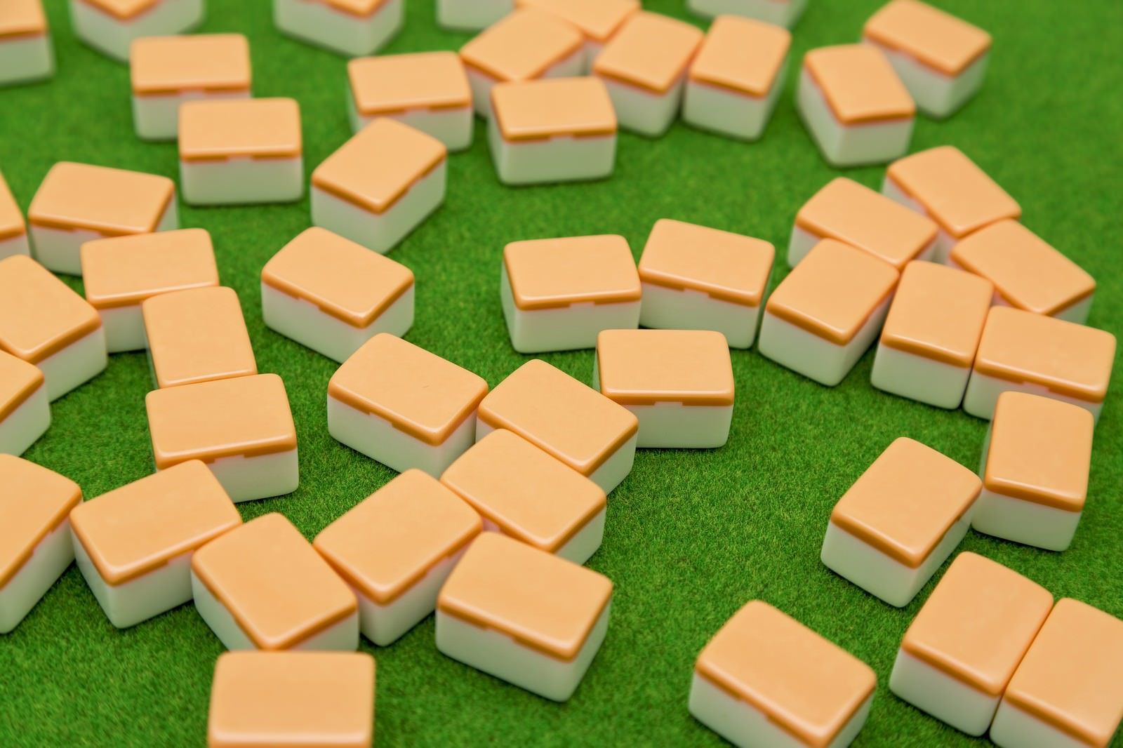 緑の人工芝の上に散らばる裏返しの麻雀牌