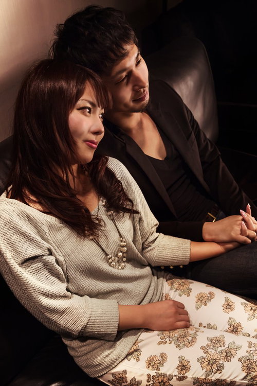 ソファーの上で手を握り合う男女