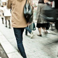 歩道を行き交う人々のブレた群像の写真